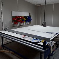 Fabric cutting table with end cutting system
